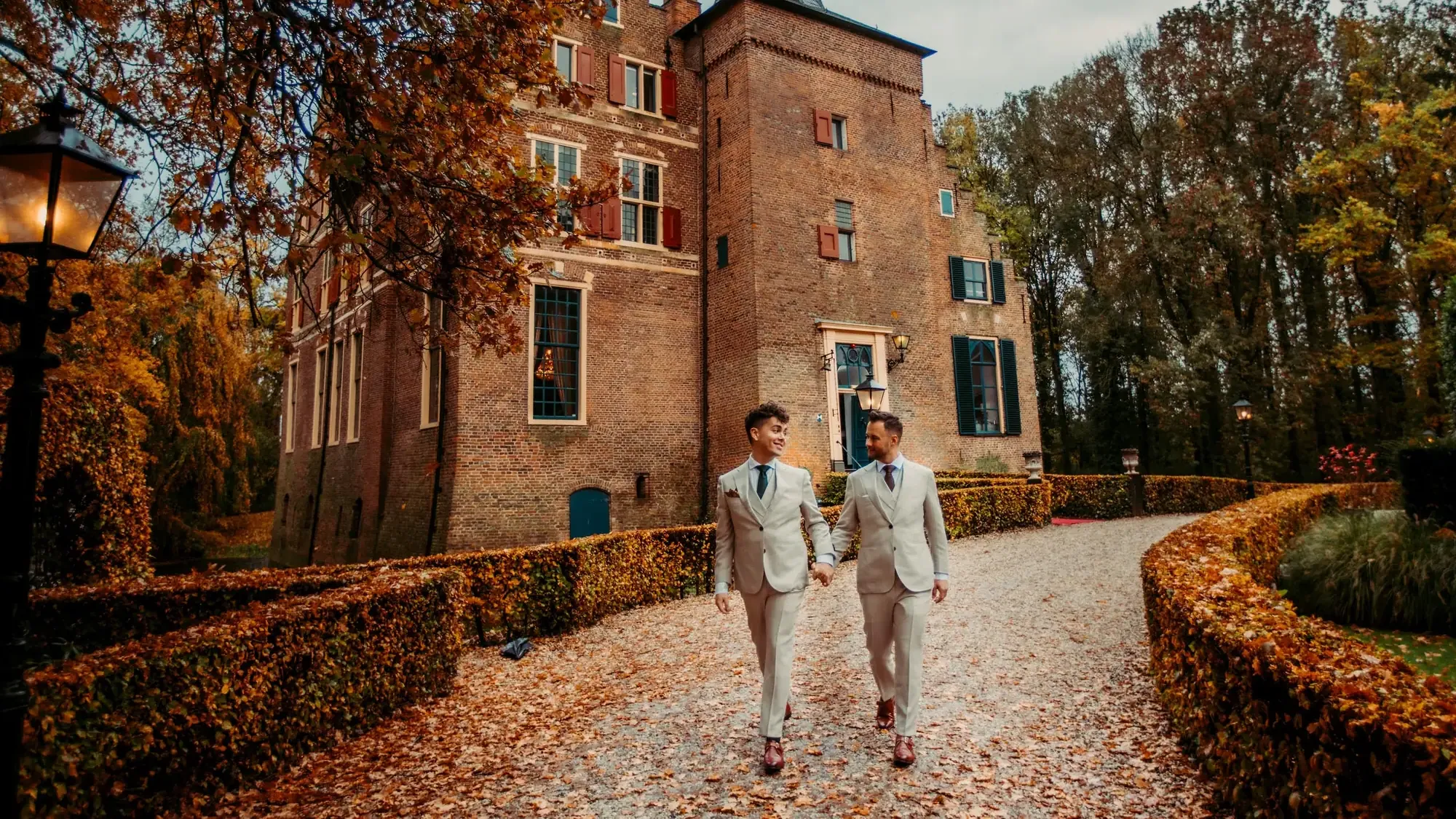 Een bruidspaar loopt over het pad naar Kasteel Wijenburg