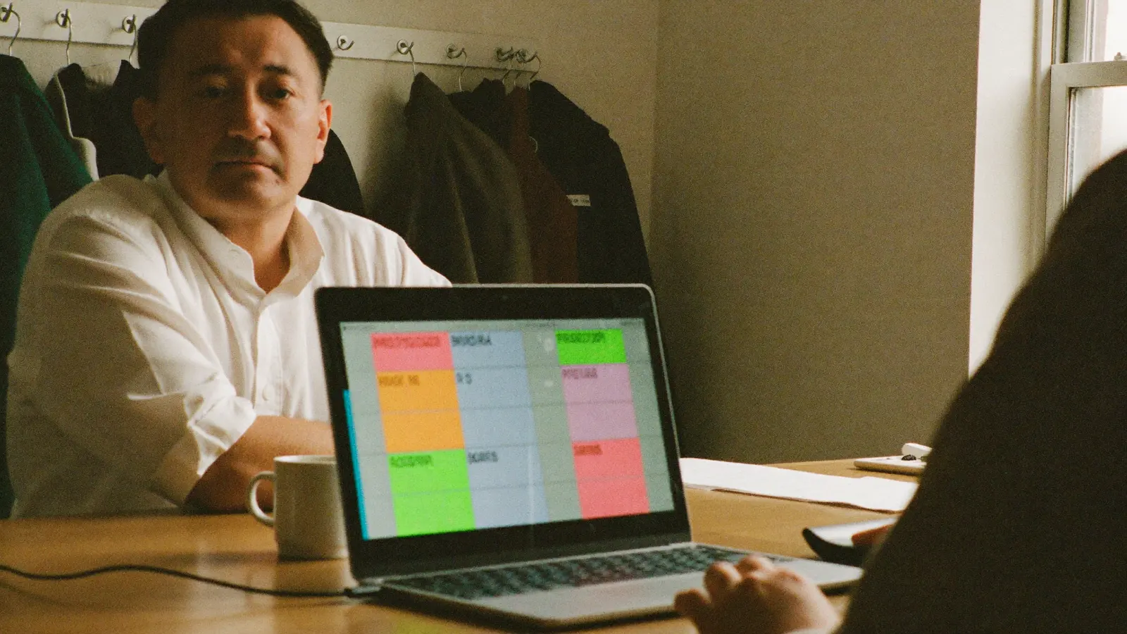 Een locatie-eigenaar in de personeelsruimte met een laptop waarop een weekplanning staat.