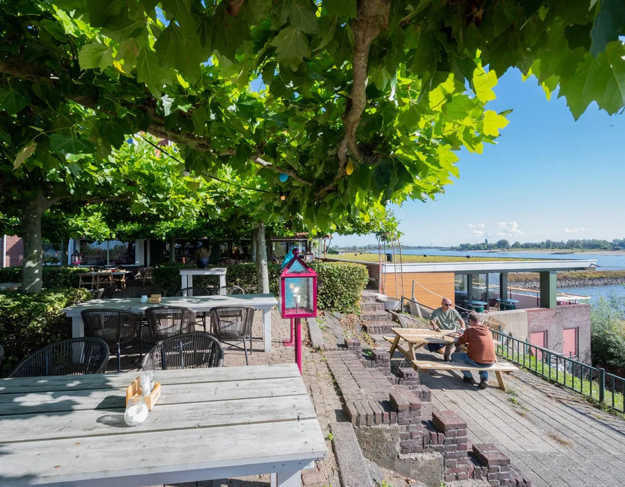 Het terras van Baiana onder de platanen, met uitzicht over het water