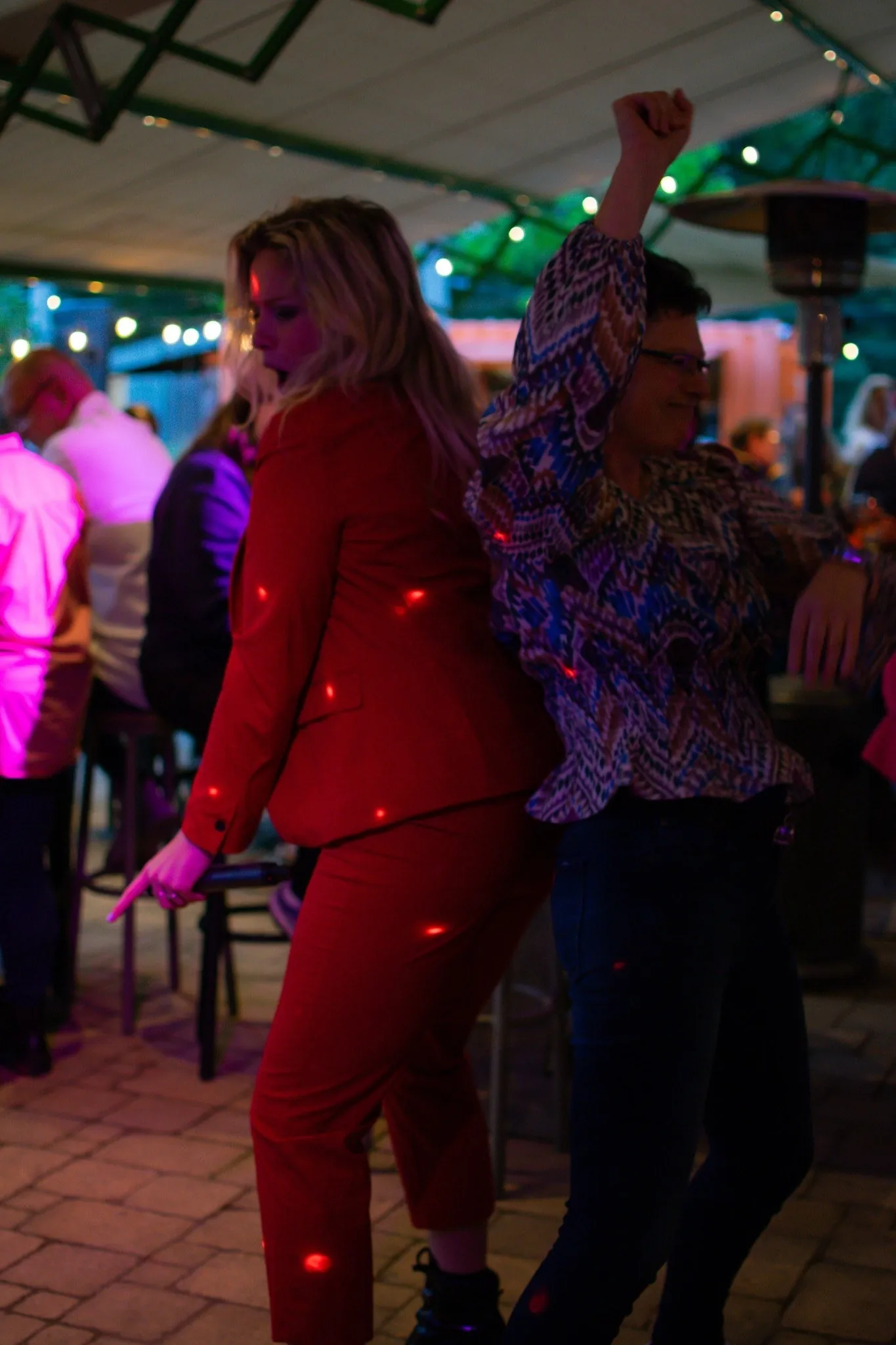 Feestende gasten in roze en paars licht