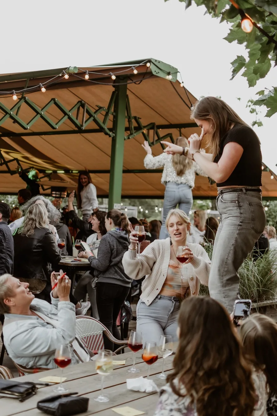 Een feest onder de tent op het terras van BOS & Co, gasten proosten aan lange tafels