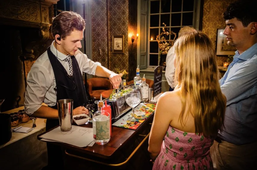 Een barman maakt een cocktail aan een mobiele bar in het kasteel